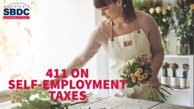 Image portrays self-employed Caucasian woman putting together a flower arrangement at her shop.
